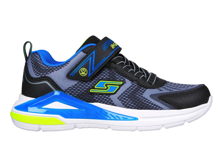 Tenis deportivos Skechers para niño en colores negro, azul y amarillo con suela blanca.
