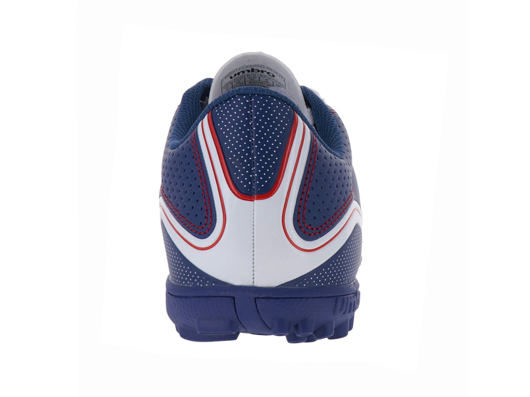 Zapato de fútbol Umbro color blanco y azul con detalles rojos y suela para césped sintético.