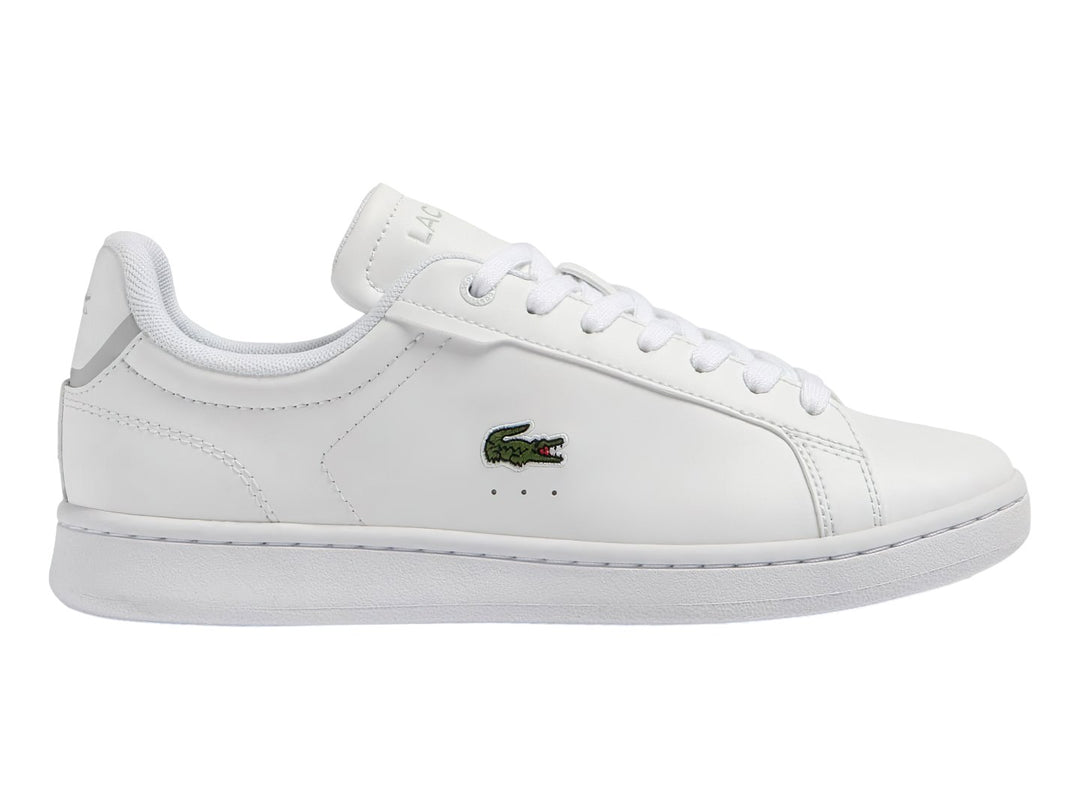 Tenis blancos de cuero para Niño marca Lacoste con logotipo del cocodrilo en el lateral.
