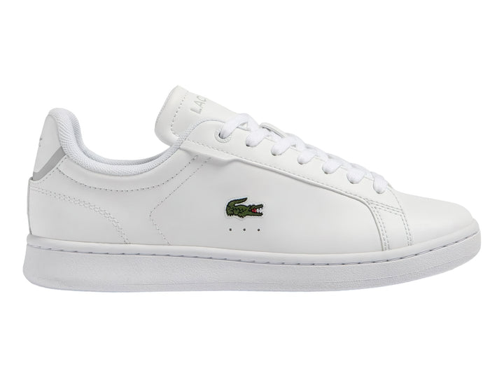 Tenis blancos de cuero para Niño marca Lacoste con logotipo del cocodrilo en el lateral.
