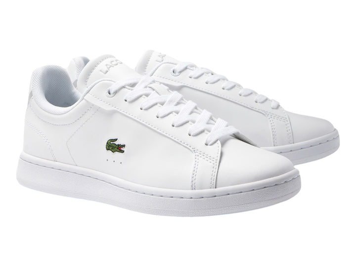 Tenis blancos de cuero para Niño marca Lacoste con logotipo del cocodrilo en el lateral.