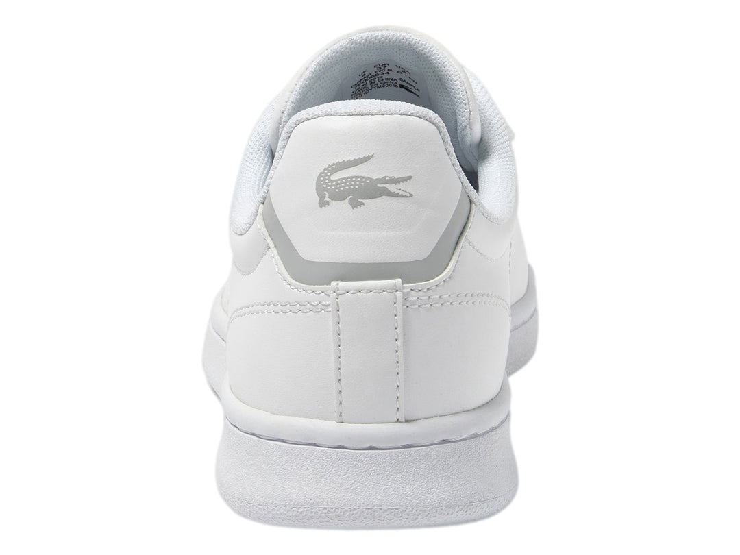 Tenis blancos de cuero para Niño marca Lacoste con logotipo del cocodrilo en el lateral.