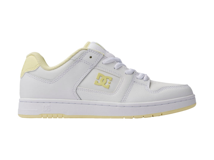 Tenis DC Shoes color blanco con detalles en amarillo y suela blanca.