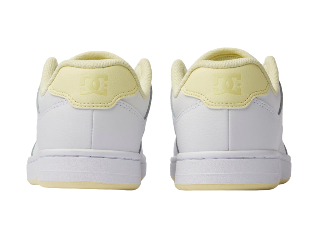 Tenis DC Shoes color blanco con detalles en amarillo y suela blanca.