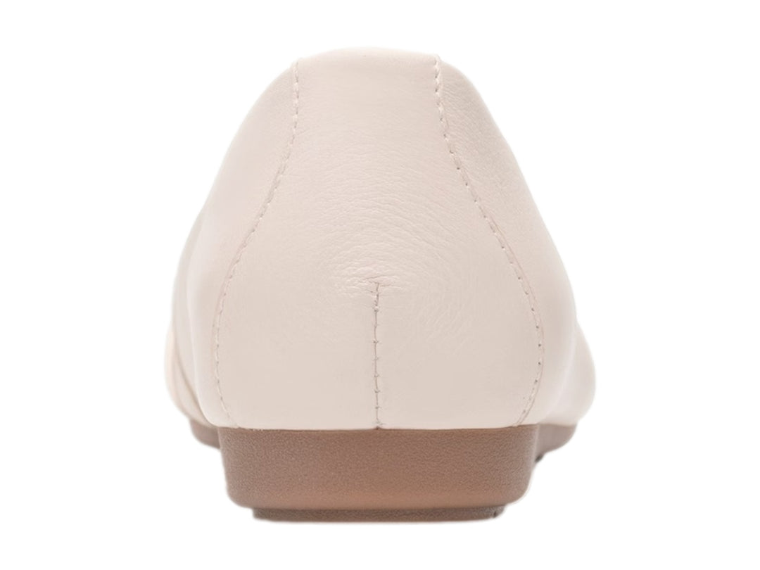 Zapato plano Flexi color latte con detalle de nudo en la punta y suela color café claro.
