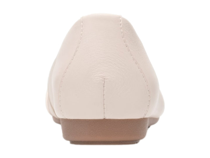 Zapato plano Flexi color latte con detalle de nudo en la punta y suela color café claro.
