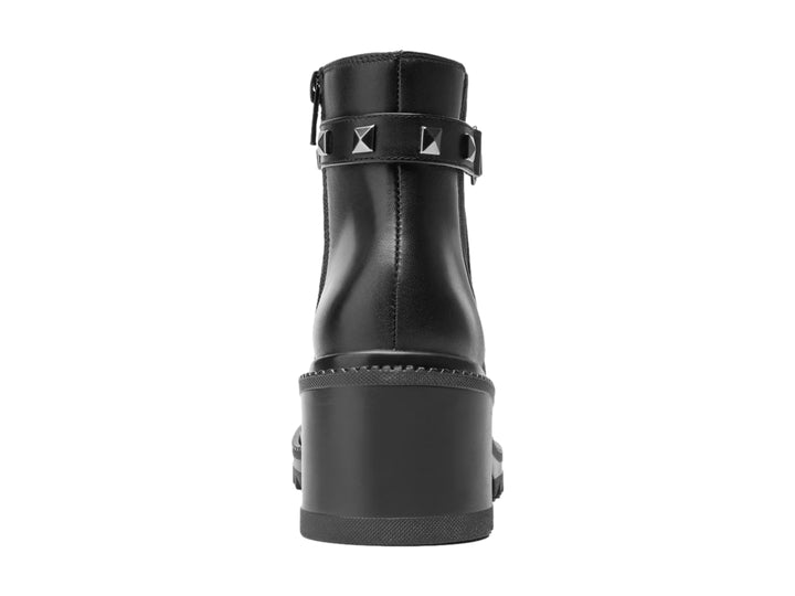 Botín Flexi de cuero negro para mujer con tacón cuadrado, suela dentada y correa decorativa con tachuelas plateadas.