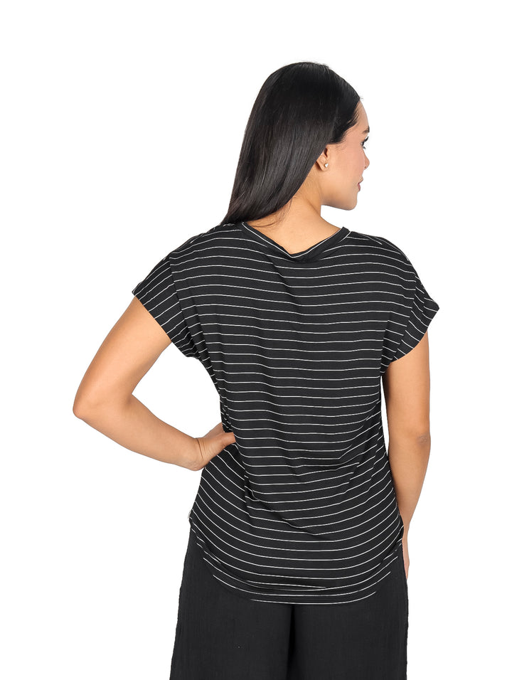Mujer vistiendo blusa negra con rayas horizontales blancas de manga corta y cuello redondo.