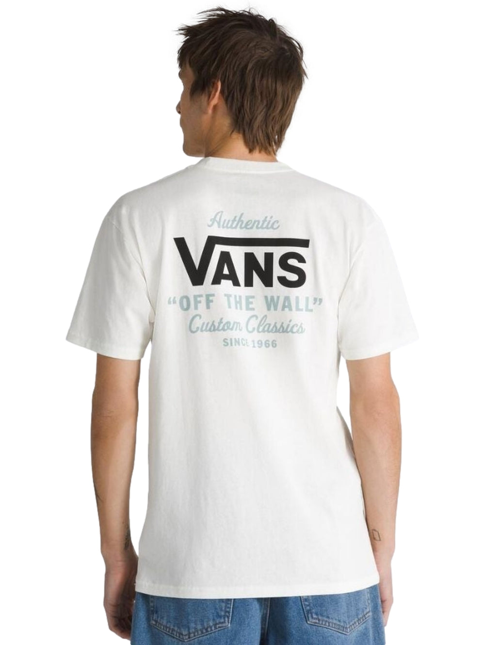 Hombre vistiendo playera blanca de manga corta marca Vans con logotipo en el pecho.