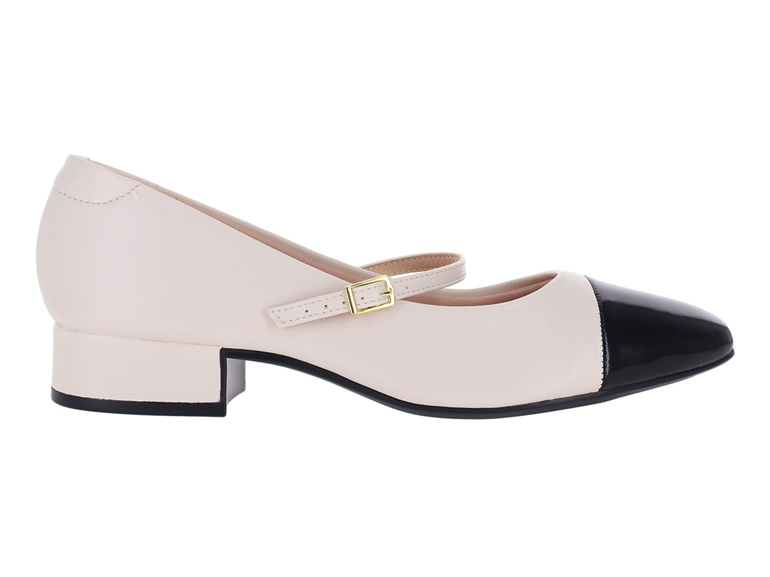 Zapato blanco de tacón bajo con punta negra brillante y correa con hebilla dorada.