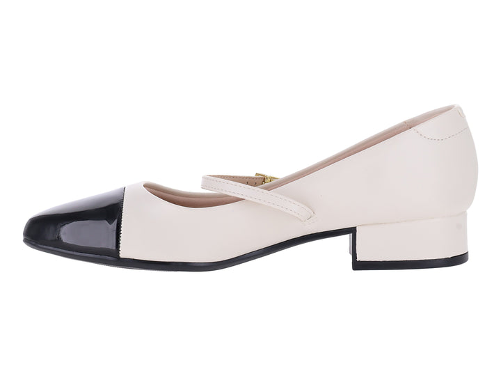 Zapato blanco de tacón bajo con punta negra brillante y correa con hebilla dorada.