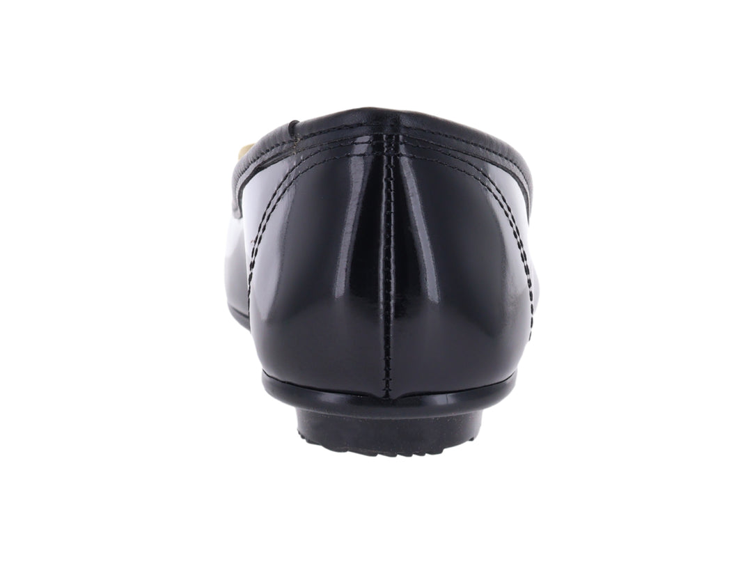 Zapato plano tipo ballerina color negro brillante con detalle decorativo dorado en la punta.