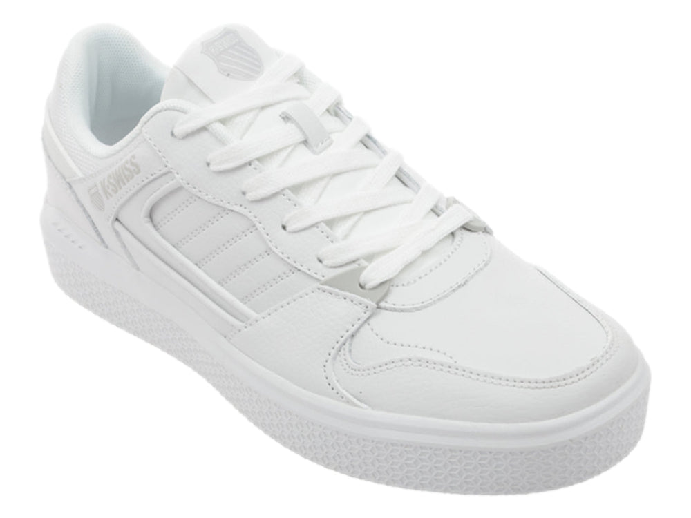 Tenis K-Swiss blancos de corte bajo con suela plana y detalles en gris.