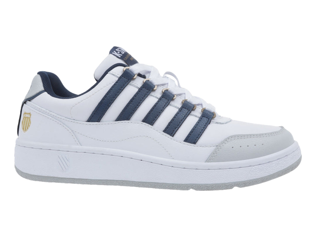 Tenis K-Swiss blancos con rayas azul marino y detalles en gris en la punta y suela.