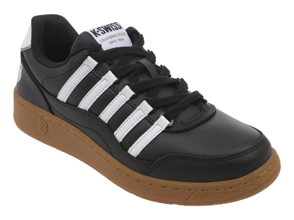 Tenis K-Swiss color negro con rayas blancas y suela de goma color marrón.