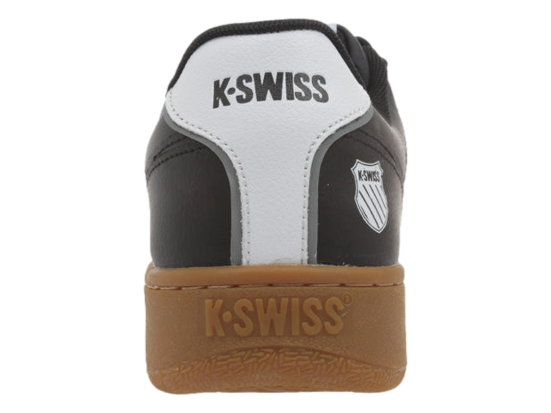 Tenis K-Swiss color negro con rayas blancas y suela de goma color marrón.
