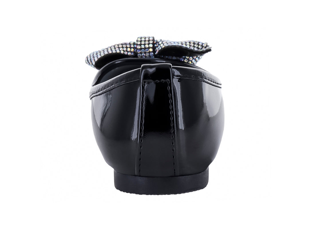 Zapato plano negro de charol brillante con un moño decorativo plateado en la punta.