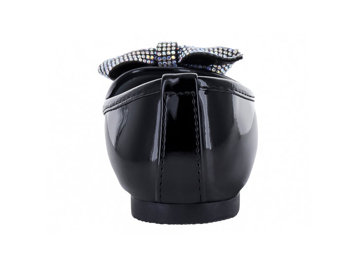 Zapato plano negro de charol brillante con un moño decorativo plateado en la punta.
