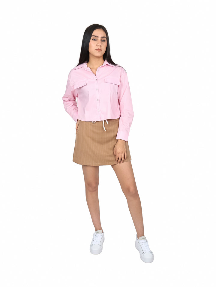 Mujer vistiendo una falda corta color beige con rayas verticales y cordón ajustable en la cintura.
