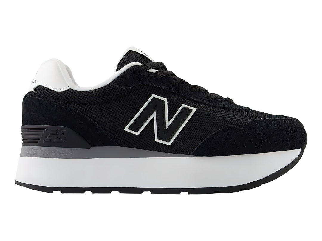 Tenis New Balance color negro con suela de plataforma blanca y detalles en gris.