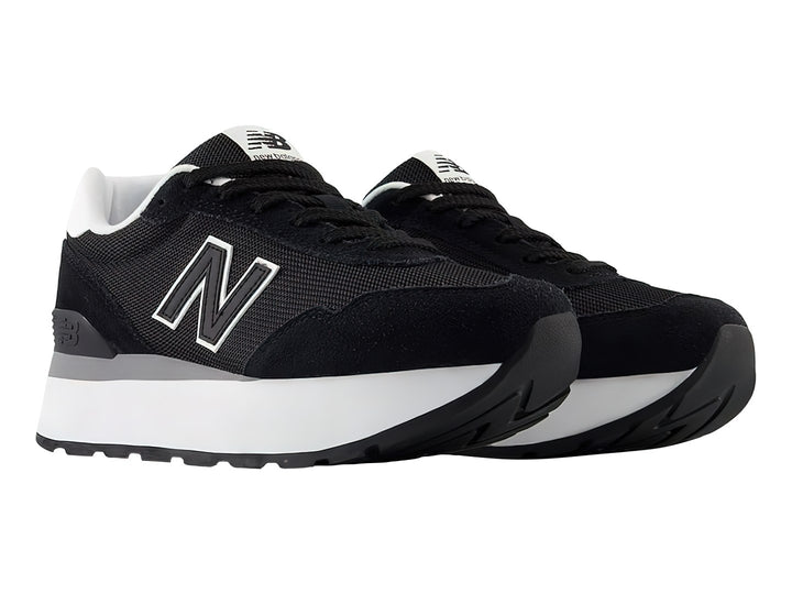 Tenis New Balance color negro con suela de plataforma blanca y detalles en gris.