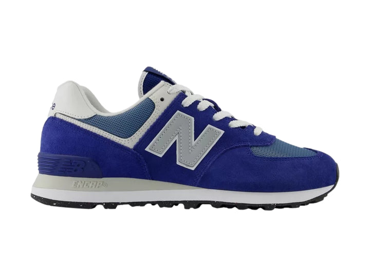 Tenis New Balance 574 color azul con detalles en gris y blanco, vista lateral sobre fondo blanco.