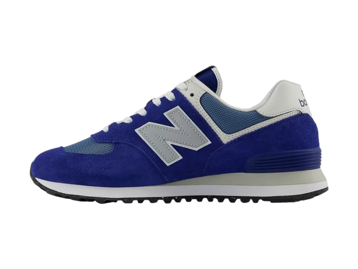 Tenis New Balance 574 color azul con detalles en gris y blanco, vista lateral sobre fondo blanco.