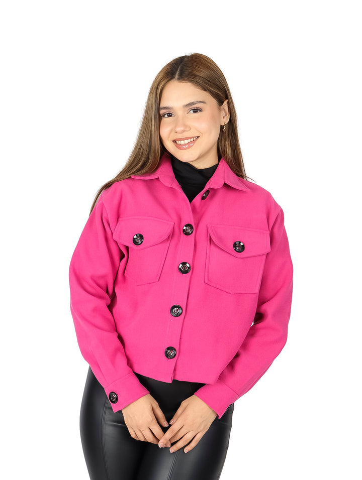 Mujer vistiendo chaqueta corta color fucsia con botones y bolsillos frontales.