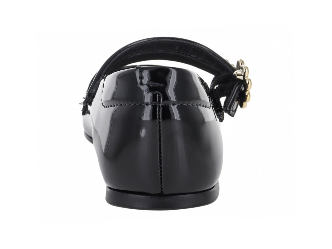 Zapato plano negro de charol para niña con dos correas decoradas con hebillas de pedrería blanca.