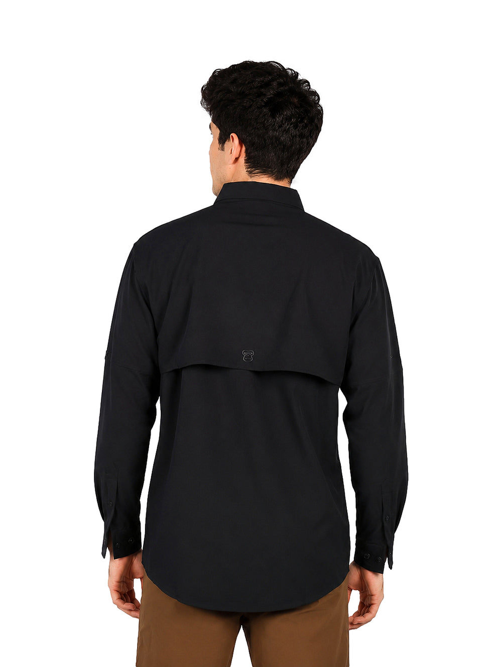 Hombre vistiendo una camisa negra de manga larga con tecnolog�a outdoor y pantalones color caf�.
