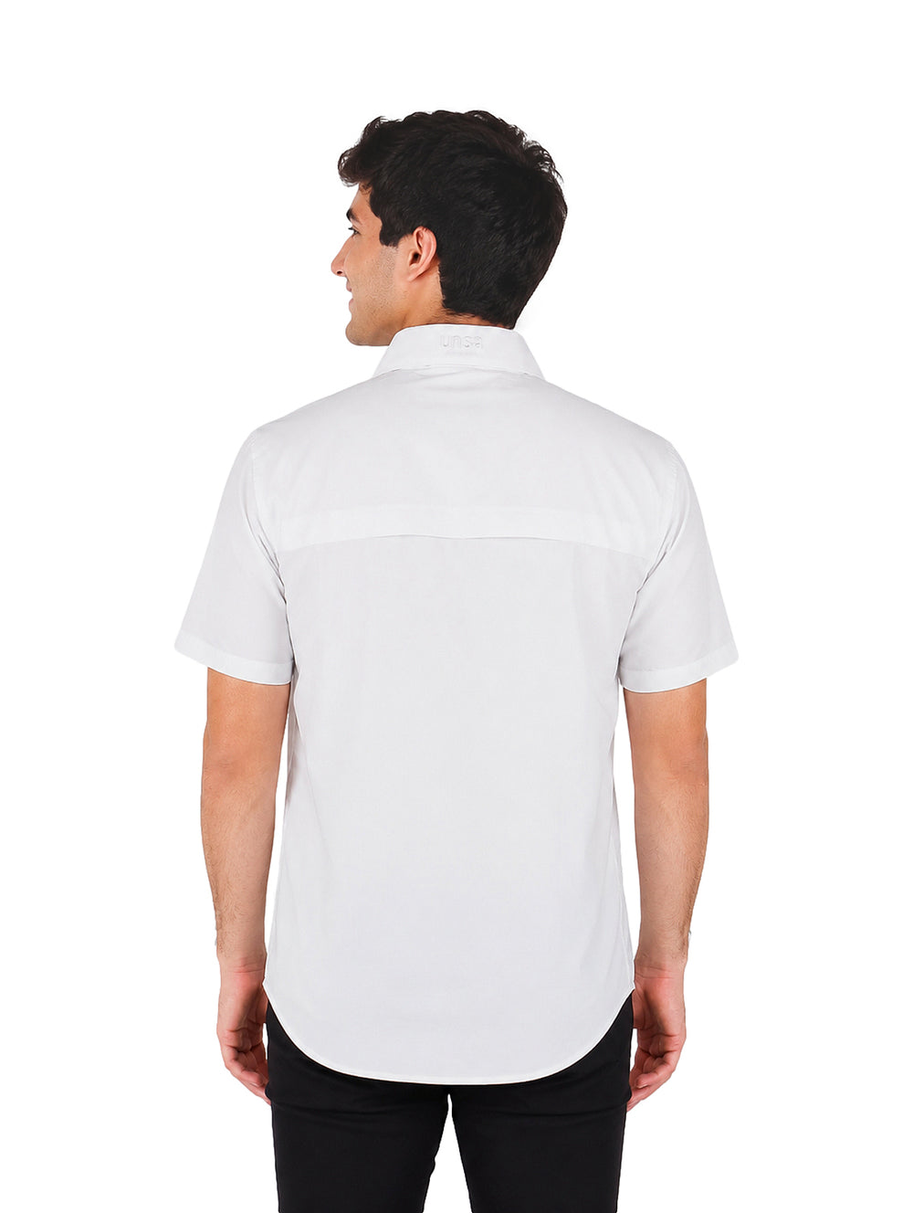 Hombre vistiendo una camisa blanca de manga corta con cuello y bolsillos frontales sobre fondo blanco.
