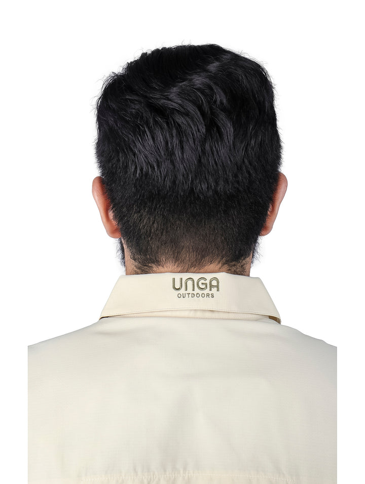 Hombre vistiendo una camisa de manga larga color beige con cuello y botones frontales.