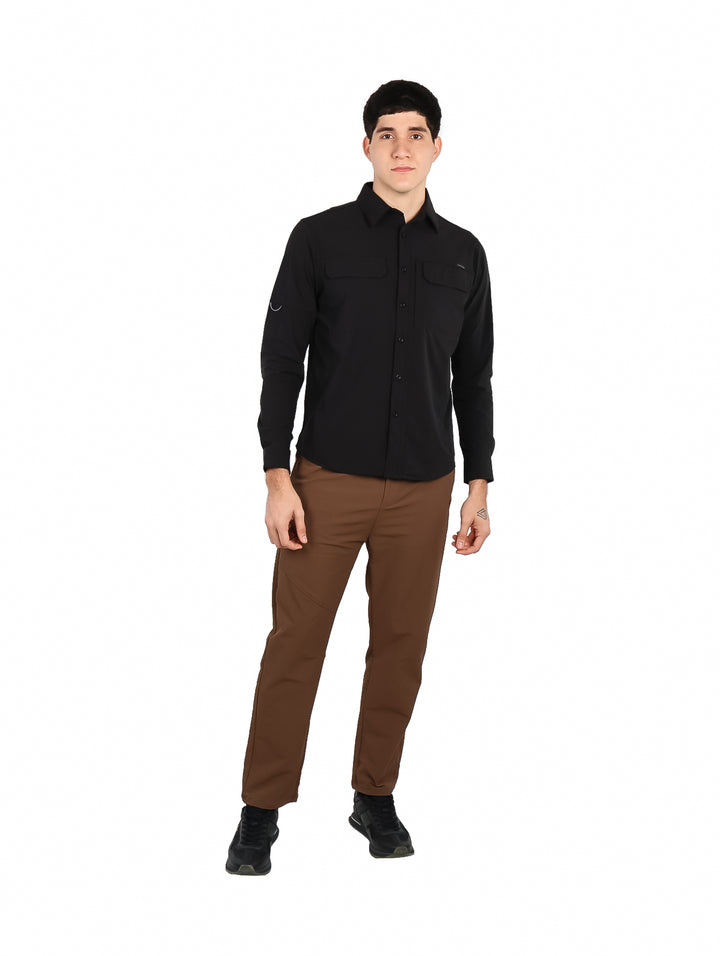 Hombre vistiendo camisa negra de manga larga con tecnolog�a outdoor y bolsillos frontales.