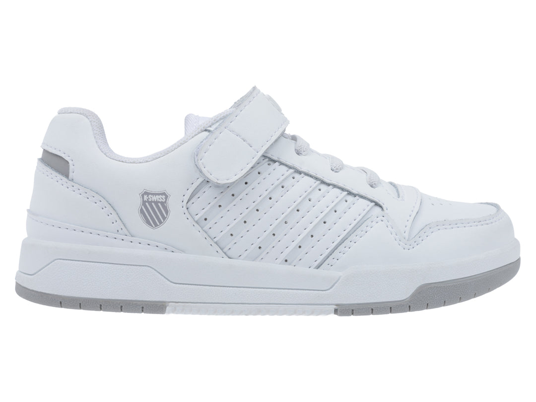 Tenis blancos K-Swiss con cierre de velcro, agujetas y suela gris.