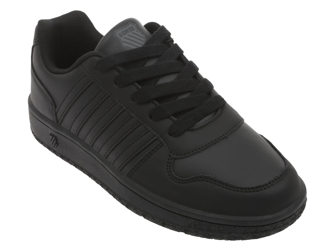 Tenis K-Swiss color negro monocromático de corte bajo con agujetas.