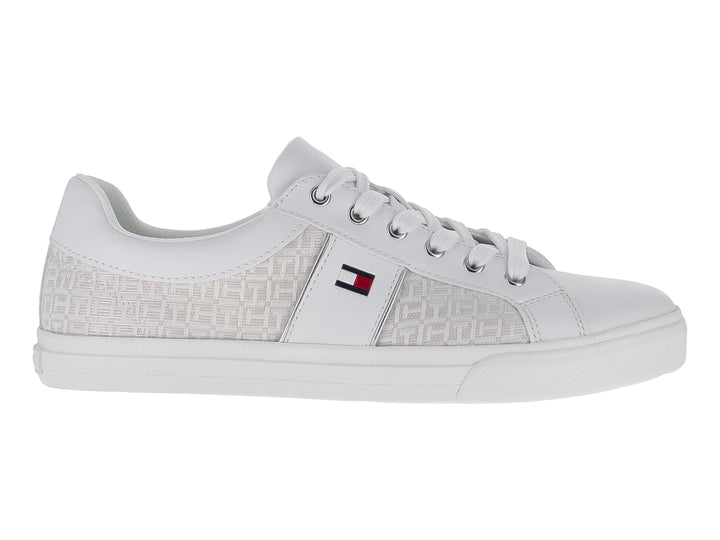 Tenis Tommy Hilfiger color marfil con estampado monograma lateral y suela blanca.