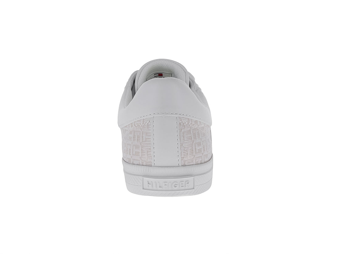 Tenis Tommy Hilfiger color marfil con estampado monograma lateral y suela blanca.