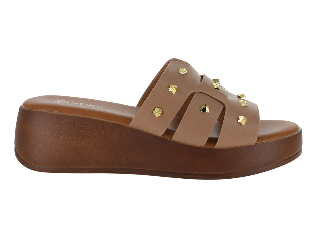Sandalia de plataforma color beige con tiras decoradas con estoperoles dorados y suela marrón.