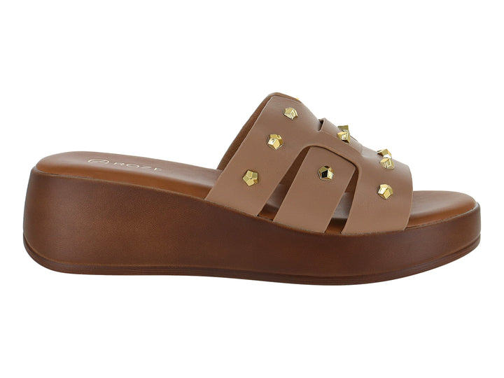Sandalia de plataforma color beige con tiras decoradas con estoperoles dorados y suela marrón.