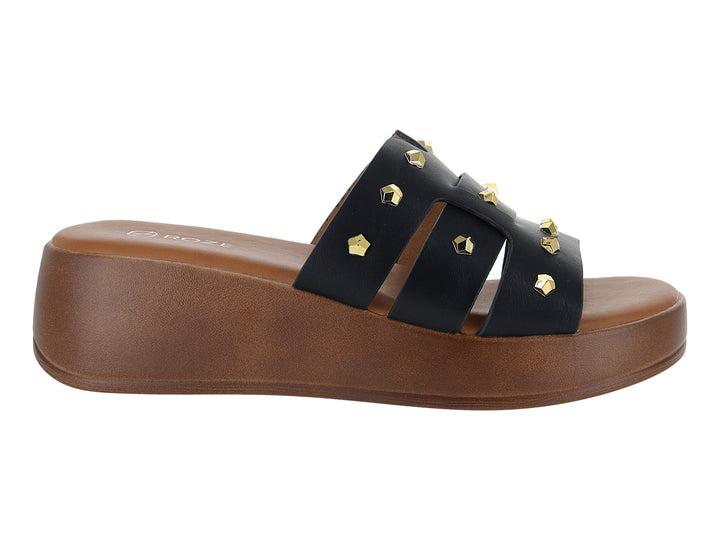 Sandalia de plataforma color negro con tiras decoradas con tachuelas doradas y suela marrón.