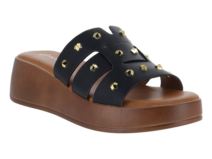 Sandalia de plataforma color negro con tiras decoradas con tachuelas doradas y suela marrón.