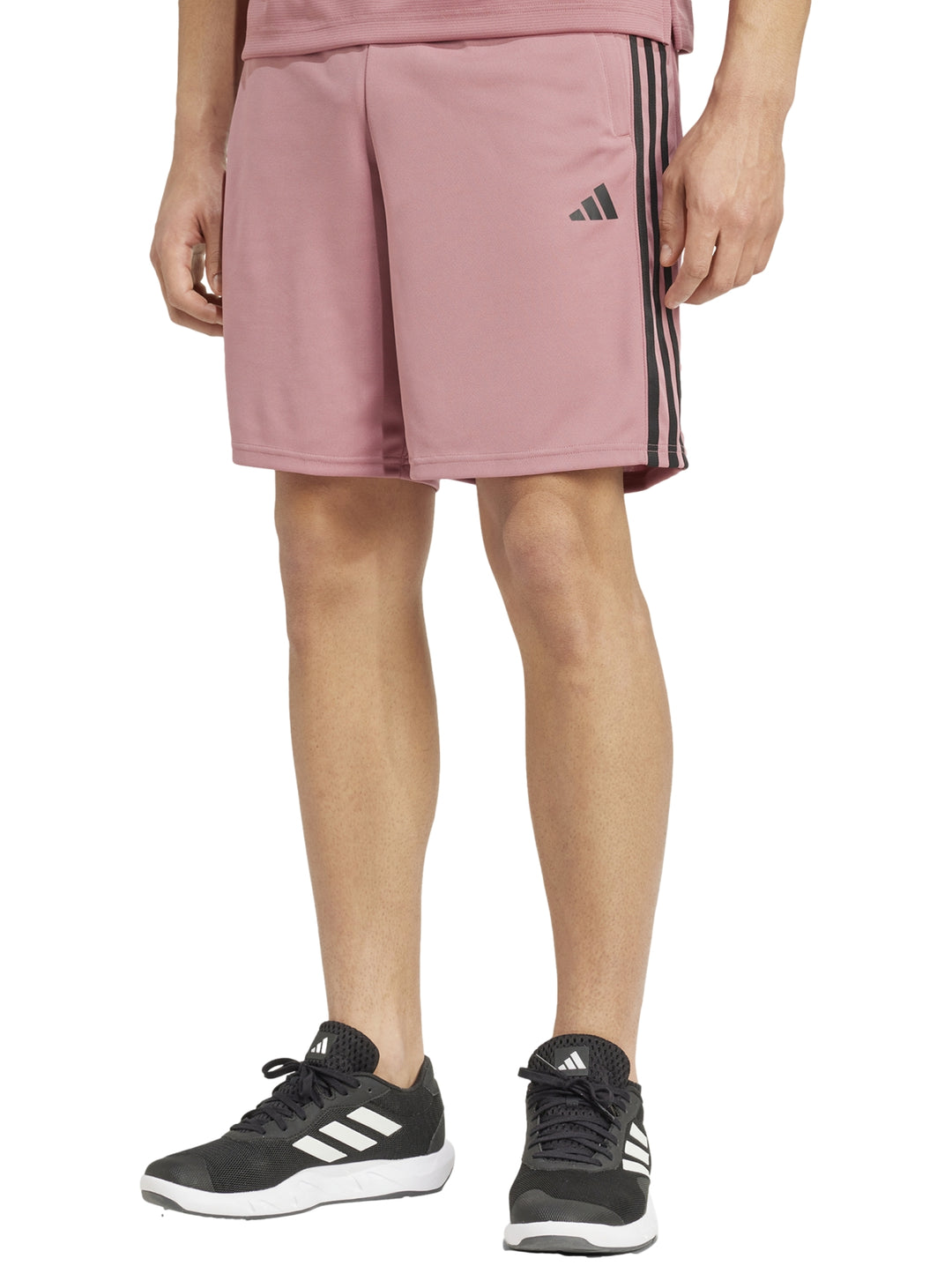 Hombre vistiendo shorts deportivos Adidas color rojo preloved crimson con tres franjas negras laterales.