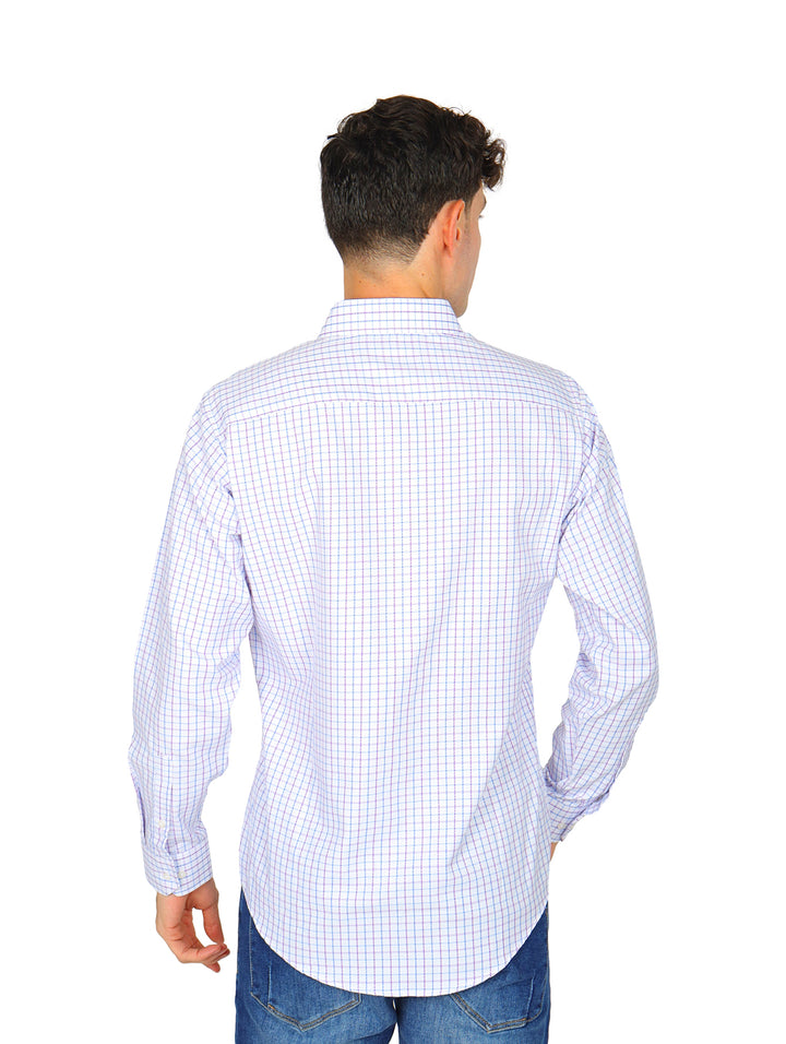 Hombre con camisa de manga larga blanca con cuadros lilas y pantalones azules.