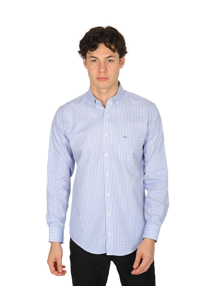 Hombre vistiendo camisa de manga larga azul con patrón de cuadros pequeños.