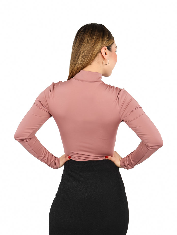 Mujer modelando un body ajustado de color morado con cuello alto y mangas largas.