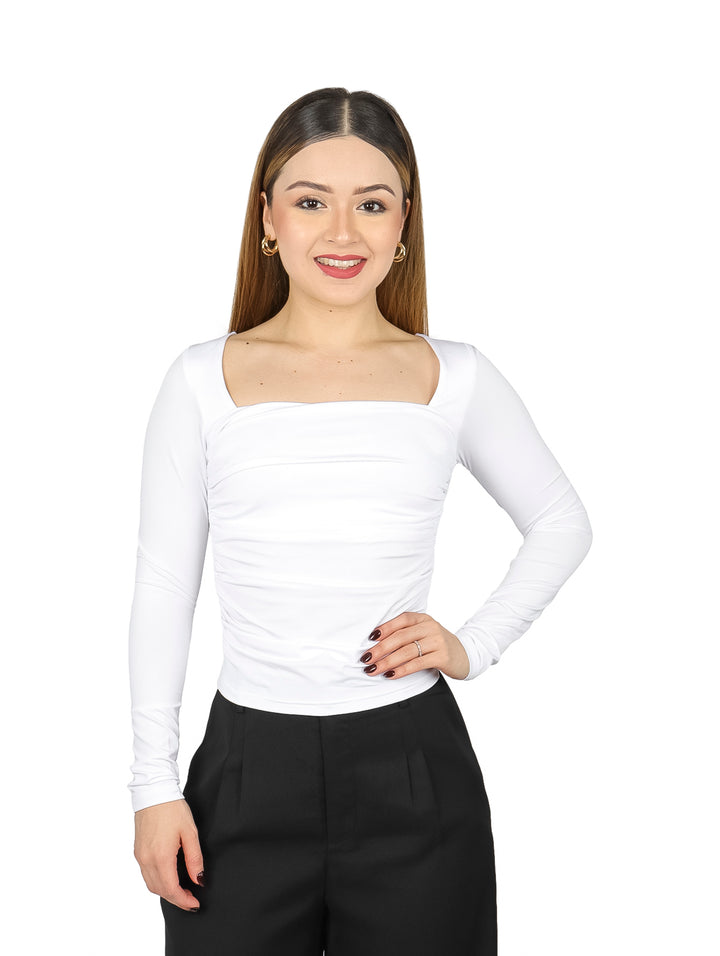 Mujer vistiendo blusa color ivory de manga larga con escote cuadrado y pantalones negros.
