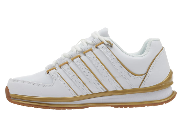 Tenis deportivos K-Swiss color blanco con detalles lineales y suela en color dorado.
