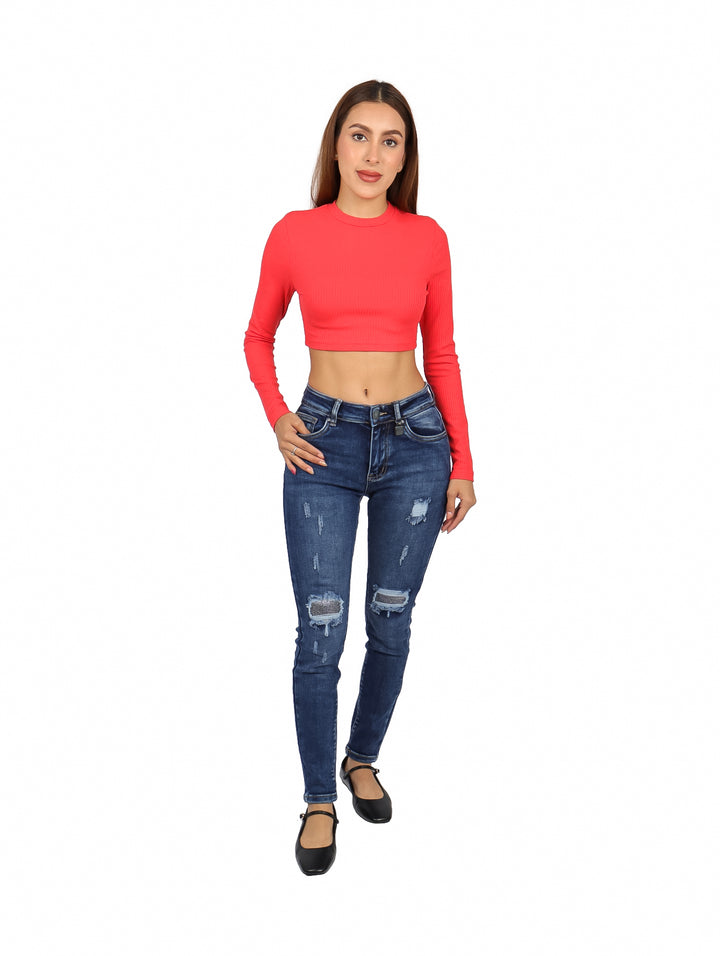Mujer vistiendo un top rojo corto de manga larga y cuello redondo.