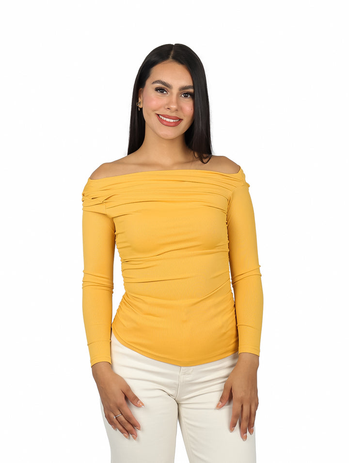 Mujer vistiendo blusa amarilla de hombros descubiertos y manga larga con textura acanalada.