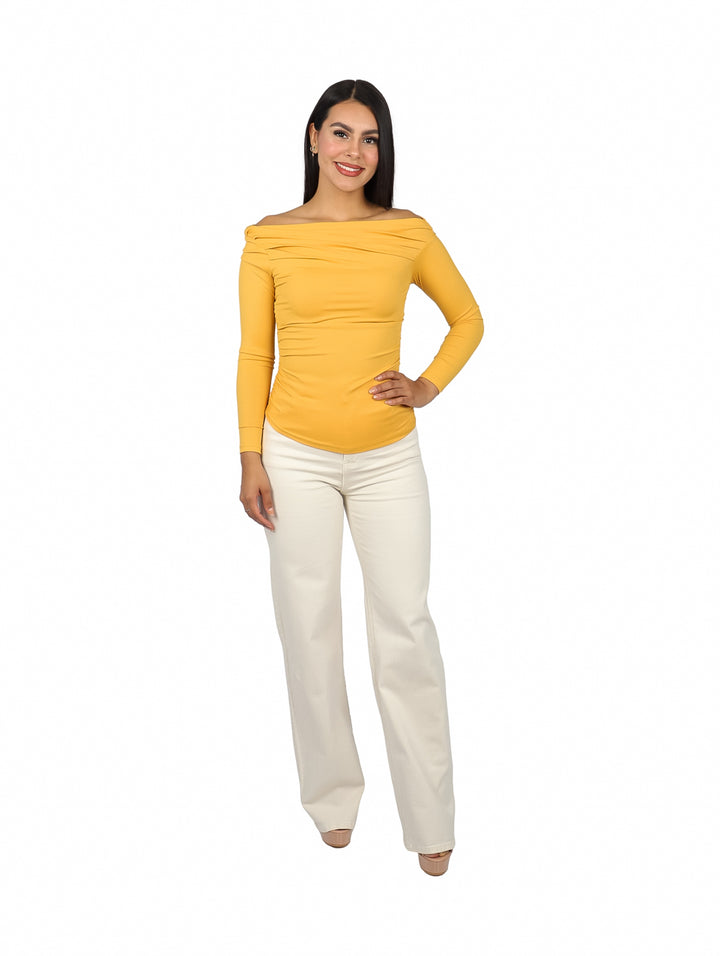 Mujer vistiendo blusa amarilla de hombros descubiertos y manga larga con textura acanalada.